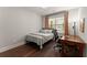 Well-lit bedroom with curtains, a desk, and hardwood floors at 5875 Windjammer Pt, Cumming, GA 30041