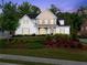 Charming two-story home featuring a lush lawn and beautiful landscaping at 5875 Windjammer Pt, Cumming, GA 30041