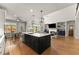 Open-concept kitchen with a large island, seating, and view into the dining and living areas at 5875 Windjammer Pt, Cumming, GA 30041