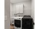 Laundry room features washer and dryer, sink, cabinetry, and wire shelving at 5875 Windjammer Pt, Cumming, GA 30041