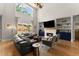 Comfortable living room with vaulted ceiling, fireplace, built-in shelves, and ample natural light at 5875 Windjammer Pt, Cumming, GA 30041