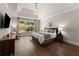Stylish main bedroom with hardwood floors and a large window overlooking the yard at 5875 Windjammer Pt, Cumming, GA 30041