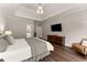 Well lit main bedroom with hardwood floors, tray ceiling and neutral paint at 5875 Windjammer Pt, Cumming, GA 30041