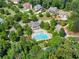 Aerial view of neighborhood pool with slide and surrounding landscaping and multiple homes at 5875 Windjammer Pt, Cumming, GA 30041