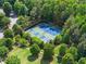 Aerial view of the neighborhood tennis and pickleball courts surrounded by trees at 5875 Windjammer Pt, Cumming, GA 30041