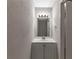 Clean bathroom featuring a bright vanity with modern lighting and a textured wall finish at 8541 Westchester Dr, Douglasville, GA 30134