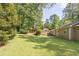 Lush green backyard with mature trees and landscaping, offering a private and serene outdoor space at 103 Sir Gregory Nw Mnr, Lawrenceville, GA 30044