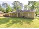 Backyard featuring green grass, mature trees, and part of the exterior of the home at 103 Sir Gregory Nw Mnr, Lawrenceville, GA 30044