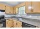 Close-up of kitchen with granite countertops, stainless steel sink, and black appliances at 103 Sir Gregory Nw Mnr, Lawrenceville, GA 30044