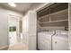 Convenient laundry room with washer, dryer, shelving, and access to a full bathroom at 250 Pharr Ne Rd # 716, Atlanta, GA 30305