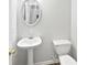 Neutral bathroom featuring pedestal sink, oval mirror, and a white toilet at 7007 Setters Way, Lithonia, GA 30038