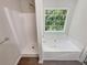 Clean bathroom with a separate tub and shower and large window with wooded backyard view at 7007 Setters Way, Lithonia, GA 30038