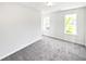 This bedroom has neutral colored walls, new gray carpet, and two windows at 7007 Setters Way, Lithonia, GA 30038