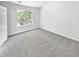 Cozy bedroom featuring neutral carpet and a leafy view from the window and adjacent door at 7007 Setters Way, Lithonia, GA 30038