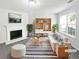 Bright living room featuring a cozy fireplace, stylish furniture, and large window for natural light at 7007 Setters Way, Lithonia, GA 30038