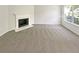 Inviting living room with cozy fireplace, plush carpeting and a bright window illuminating the space at 7007 Setters Way, Lithonia, GA 30038
