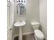 Compact powder room with a sink and a toilet with neutral walls and flooring at 7007 Setters Way, Lithonia, GA 30038