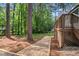 Landscaped backyard features mature trees, wood deck, and a charming gravel path at 106 Hickory Ave, Fayetteville, GA 30215