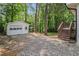 Spacious backyard with shed access, mature trees, and a gravel drive at 106 Hickory Ave, Fayetteville, GA 30215