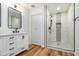 Beautiful bathroom featuring a vanity, mirror, and tiled shower with black fixtures and a glass shower door at 106 Hickory Ave, Fayetteville, GA 30215