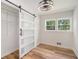 Cozy bedroom with hardwood floors, barn door closet, a modern ceiling fan and a window at 106 Hickory Ave, Fayetteville, GA 30215