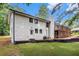 Rear exterior showcases a white brick home with a cozy wood deck overlooking the expansive lawn at 106 Hickory Ave, Fayetteville, GA 30215