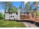 Spacious home exterior with a white brick facade, a dark trim, and a large wood deck at 106 Hickory Ave, Fayetteville, GA 30215