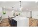 Kitchen features a center island with waterfall countertop, stainless steel appliances, and stylish light fixtures at 106 Hickory Ave, Fayetteville, GA 30215