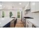 Kitchen boasts a large island with stainless steel sink and black cabinets under the waterfall countertop at 106 Hickory Ave, Fayetteville, GA 30215