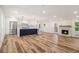 Open-concept living space with modern kitchen, hardwood floors, and brick fireplace for cozy living at 106 Hickory Ave, Fayetteville, GA 30215