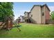 Expansive backyard with lush green grass, a playset, and mature trees at 4415 Saint Andrews Crest Dr, Cumming, GA 30040