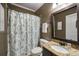 Bathroom featuring granite countertop vanity with a framed mirror and patterned shower curtain at 4415 Saint Andrews Crest Dr, Cumming, GA 30040
