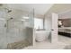 Elegant bathroom features a glass enclosed shower and a soaking tub next to a window at 4415 Saint Andrews Crest Dr, Cumming, GA 30040