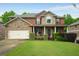 Charming two-story home with a brick and stone facade, manicured lawn, and inviting front porch at 4415 Saint Andrews Crest Dr, Cumming, GA 30040