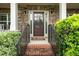 Close-up of the front door with sidelights, brick steps, and black iron railings at 4415 Saint Andrews Crest Dr, Cumming, GA 30040