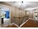 Hallway with hardwood floors, iron railing staircase, and access to multiple rooms at 4415 Saint Andrews Crest Dr, Cumming, GA 30040