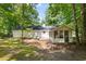 Spacious backyard featuring mature trees, a screened porch, and a deck at 121 Danielle Ct, Villa Rica, GA 30180