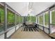 Bright sunroom with tiled floor, ceiling fan and views of wooded backyard at 121 Danielle Ct, Villa Rica, GA 30180