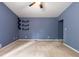 A carpeted room with blue walls with three black shelves mounted on the wall at 1741 Branch View Dr, Marietta, GA 30062