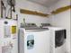 Bright laundry area with a washer, dryer, water heater and wooden shelves at 1741 Branch View Dr, Marietta, GA 30062