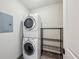 A compact laundry room includes a stacked washer and dryer unit, and metal shelving at 2233 Peachtree Ne Rd # 903, Atlanta, GA 30309