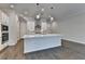 Spacious kitchen with stainless steel appliances, a large island, and stylish lighting, complemented by hardwood floors at 240 Walker Avenue, Roswell, GA 30076
