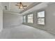 Spacious main bedroom with neutral tones, carpet, fan, and lots of natural light from multiple windows at 240 Walker Avenue, Roswell, GA 30076