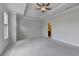 Large main bedroom featuring tray ceilings, carpet flooring, and entrance to bathroom at 240 Walker Avenue, Roswell, GA 30076