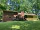 Backyard view of a full brick house with a wooden deck and a well-maintained lawn at 9278 Seminole Rd, Jonesboro, GA 30236