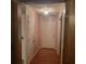 Hallway featuring pink walls, wood-look floors, and a white front door with a storm door at 9278 Seminole Rd, Jonesboro, GA 30236
