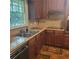 Kitchen featuring countertops, double sinks, wood cabinets, and a window with a green view at 9278 Seminole Rd, Jonesboro, GA 30236