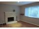 Cozy living room with wood floors, brick fireplace, and a window providing natural light at 1425 Watercrest Cir, Lawrenceville, GA 30043