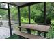 Screened-in porch with wood table and bench overlooking backyard at 1425 Watercrest Cir, Lawrenceville, GA 30043