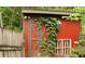 Quaint red shed surrounded by greenery and wooden fence for added privacy and storage at 1425 Watercrest Cir, Lawrenceville, GA 30043